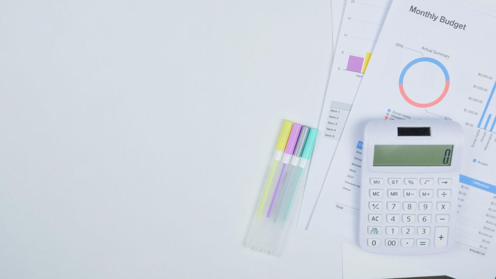 Calculator and budget planning documents on an office desk — estimating elevator modernization cost