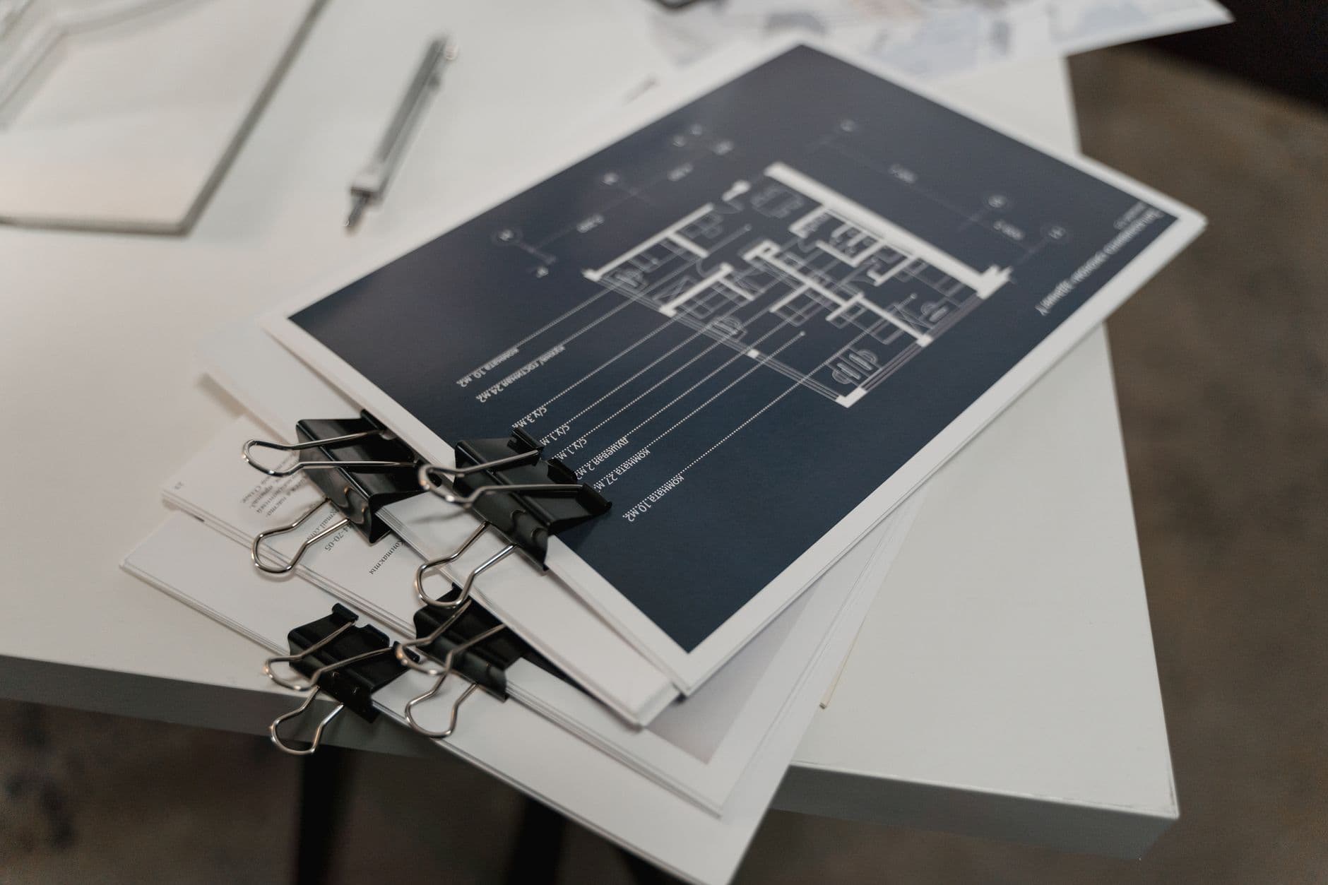 Two elevator proposal documents laid side by side on a desk being compared line by line