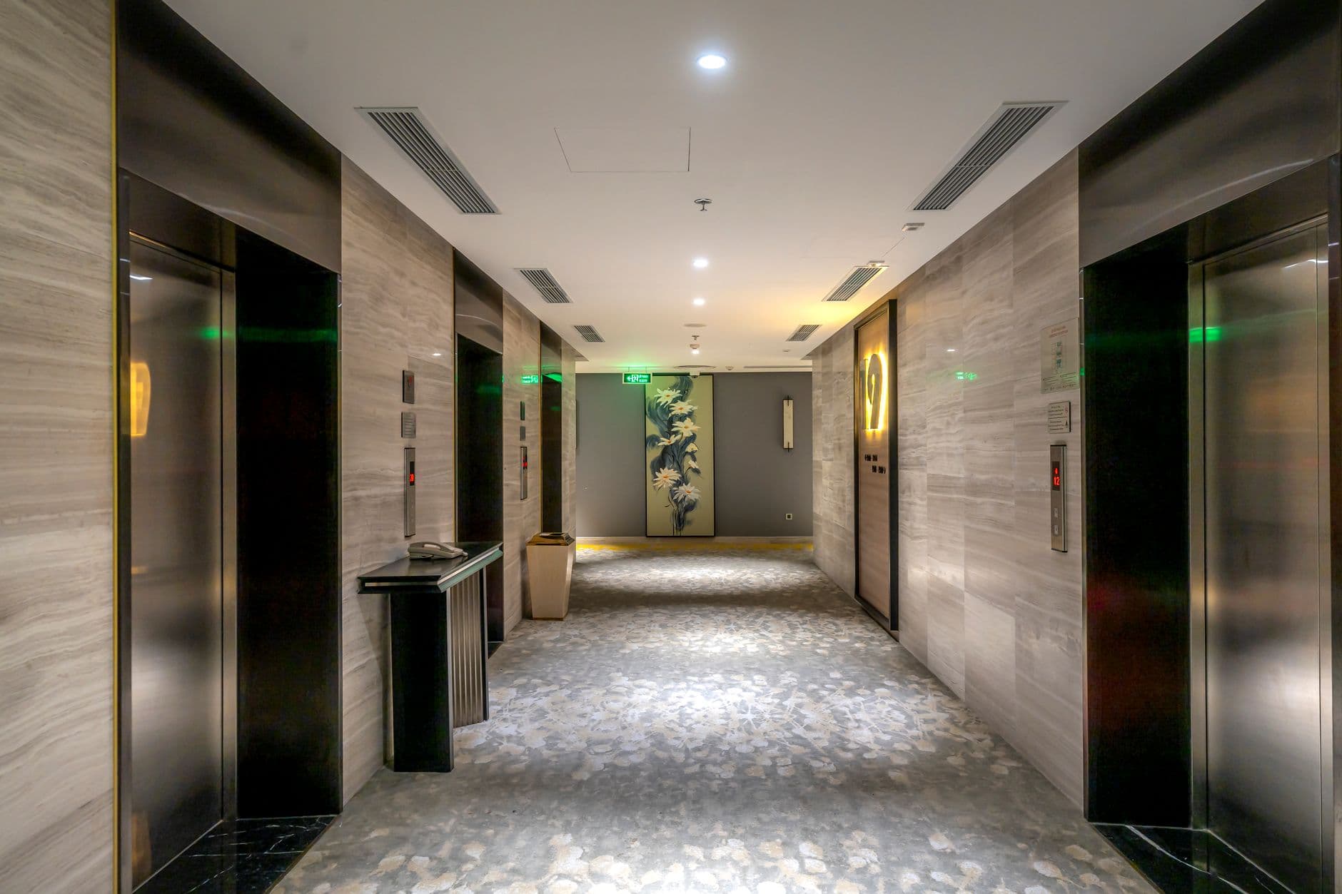Elevator lobby in a Miami coastal condo building with visible signage near the doors