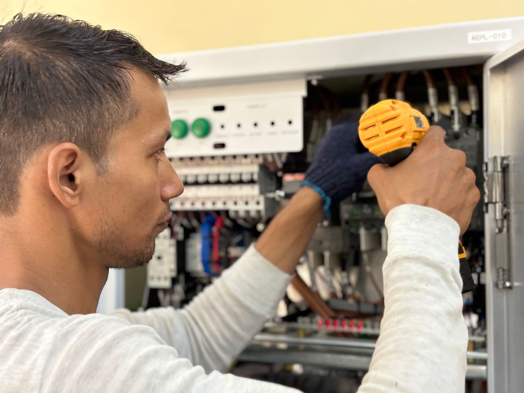 Elevator technician inspecting control panel during routine maintenance
